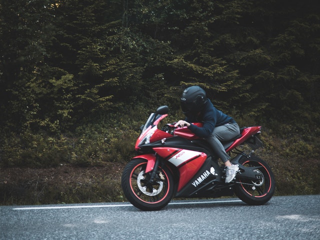 Jazdec na červenej motorke Yamaha, čierna moto prilba.jpg